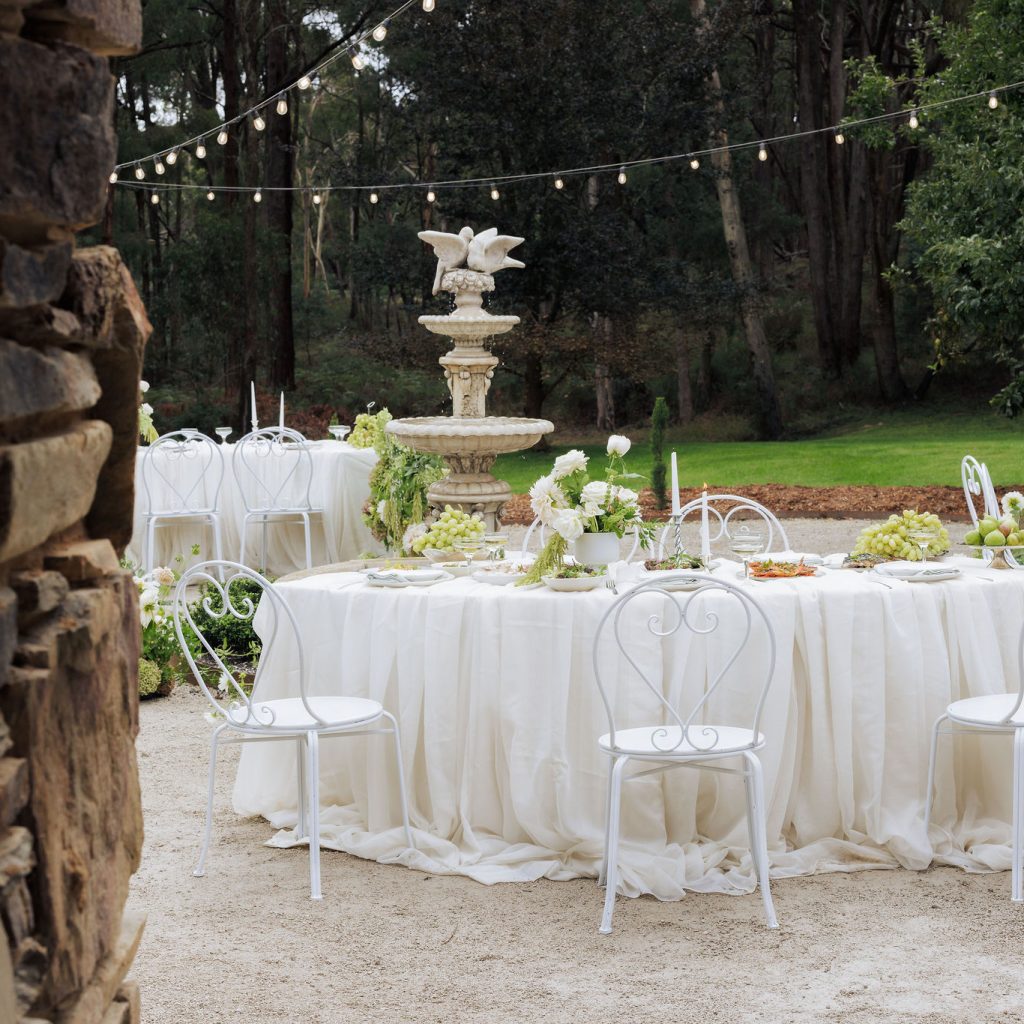 Outdoor garden table setting with fountain and lights