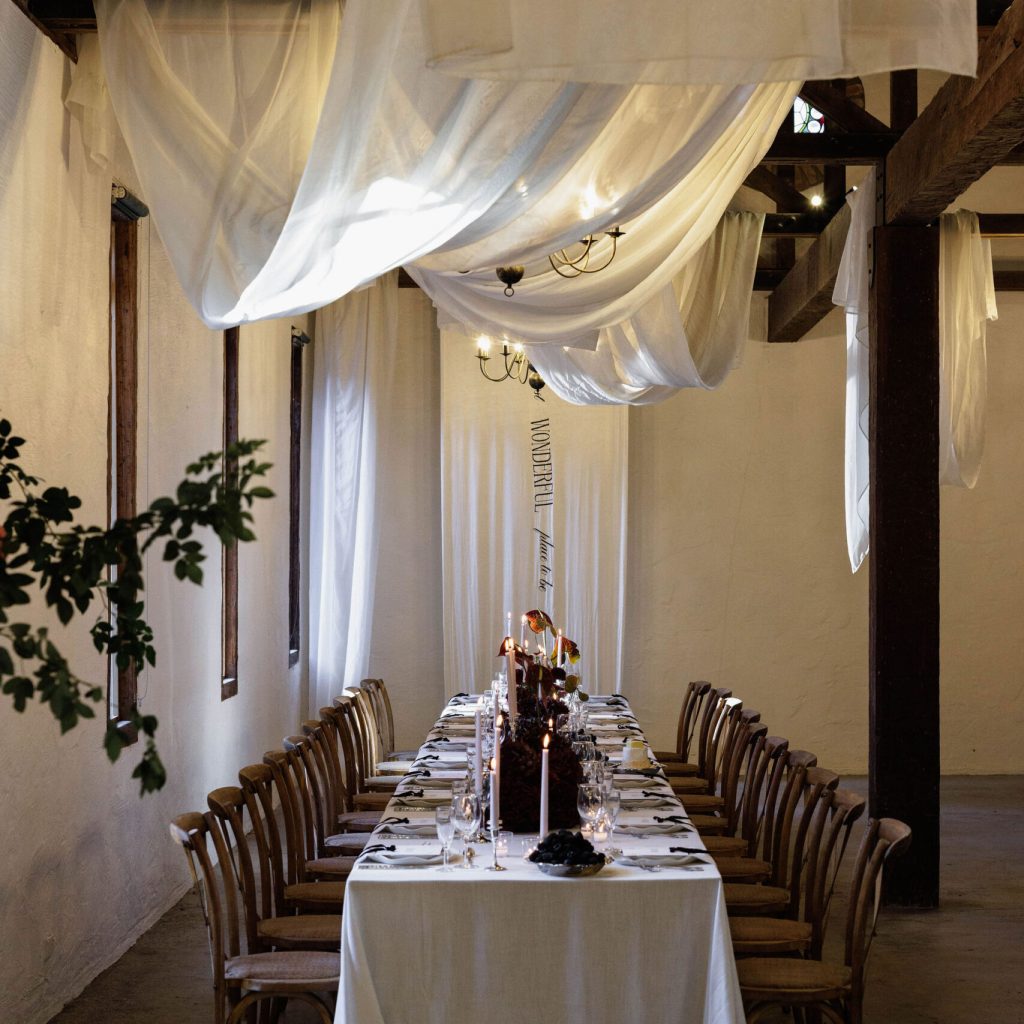 Elegant rustic dining table with draped ceiling fabric